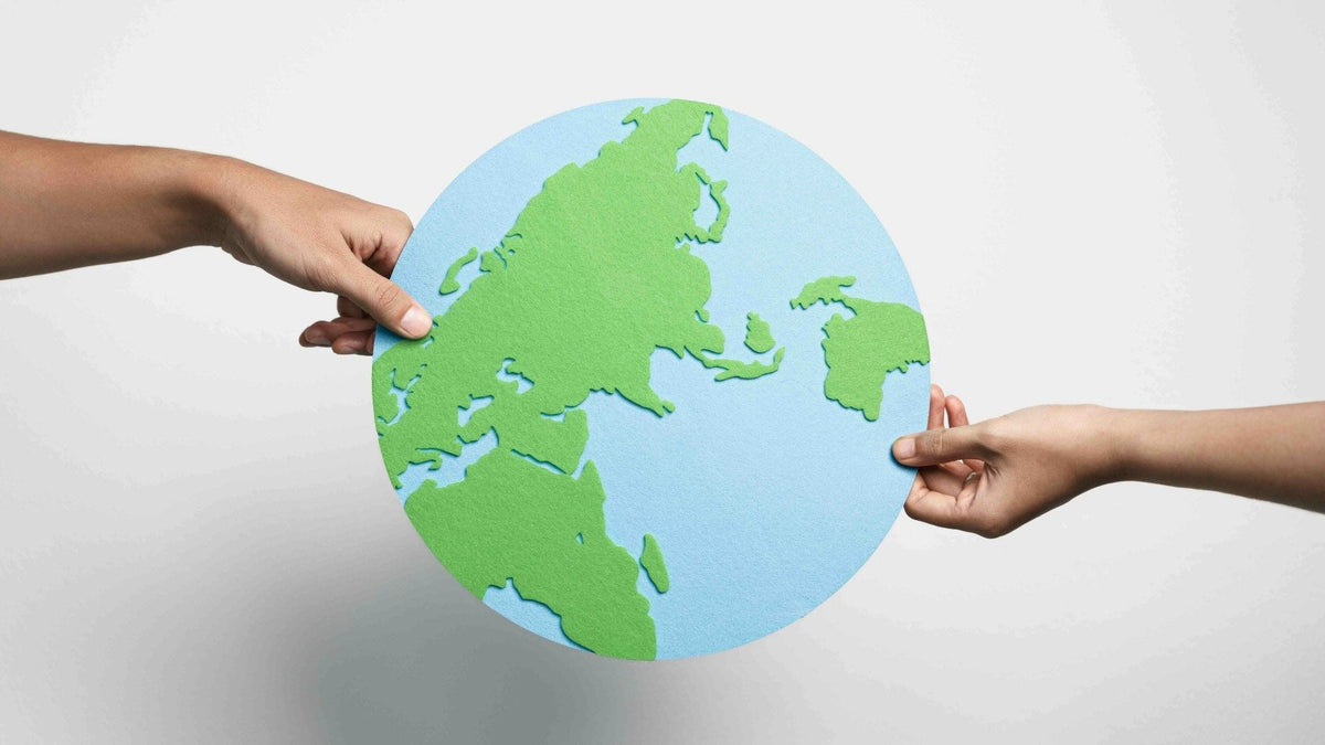 Two hands holding a stylized globe for a guide to how cannabis packaging can support social change.