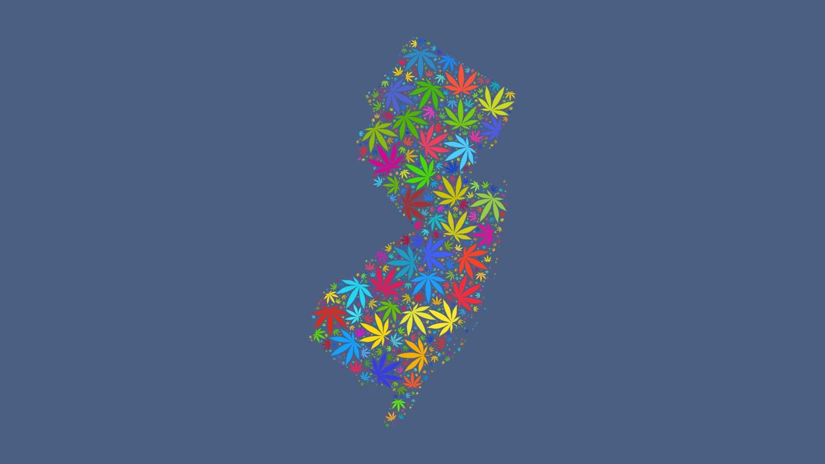 New Jersey silhouette made from multicolored cannabis leaves on a muted blue background.