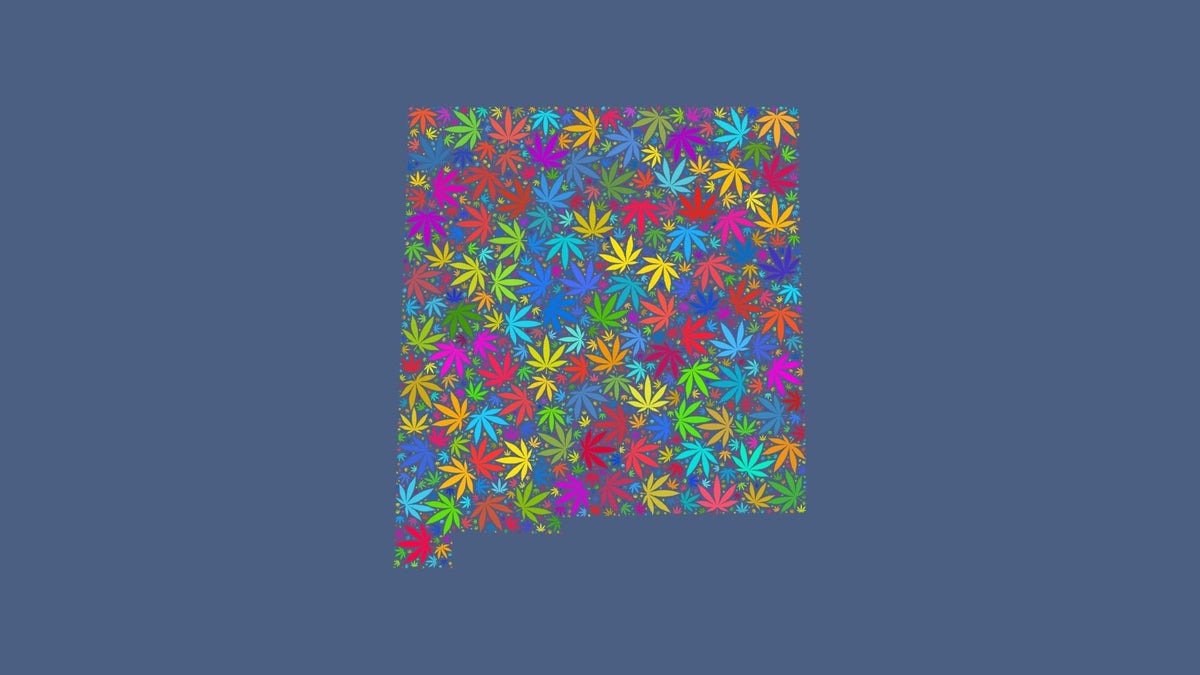 New Mexico silhouette made from multicolored cannabis leaves on a muted blue background.