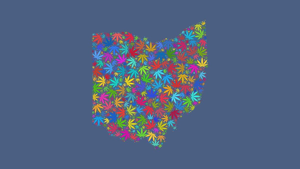 Ohio silhouette made from multicolored cannabis leaves on a muted blue background.