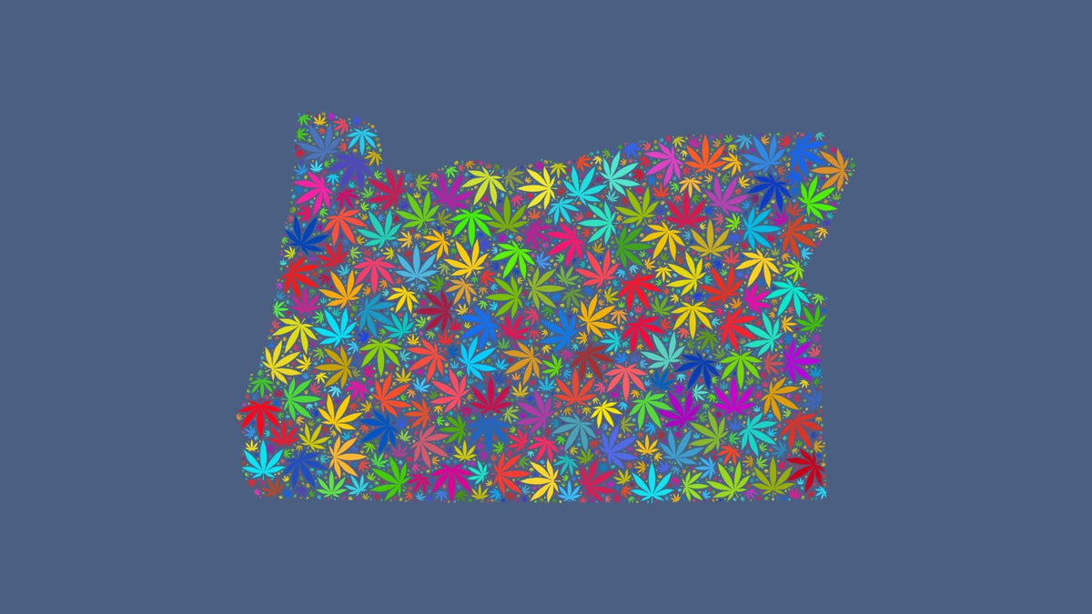 Oregon silhouette made from multicolored cannabis leaves on a muted blue background.