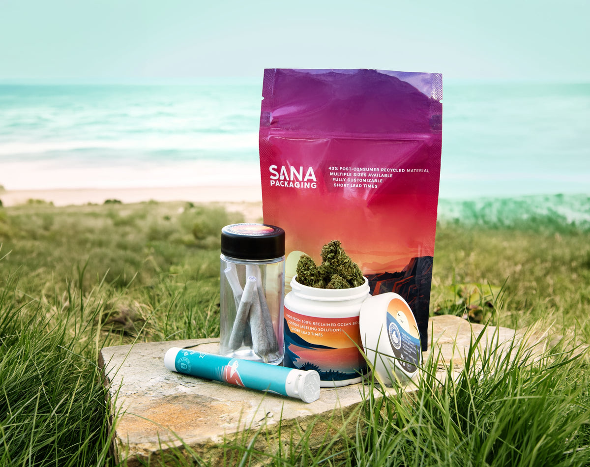 Sana Packaging flexible pouch, jars and pre-roll tube on a stone in beach grass